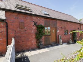 An exterior view of a brick building with wooden features at Woodpecker Cottage in Llangollen