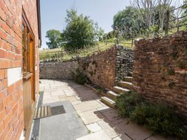 An outdoor area with a stone wall and steps at Woodpecker Cottage in Llangollen