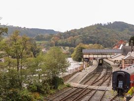A train station with multiple rail tracks and nearby trees at Woodpecker Cottage in Llangollen