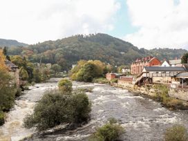 A view of a river with buildings alongside at Woodpecker Cottage in Llangollen