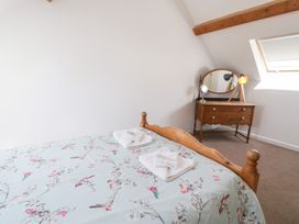 A bedroom with a bed and dressing table at Owl Cottage in Llangollen