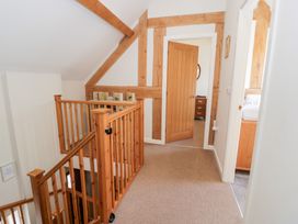A hallway with a staircase and doorways at Owl Cottage in Llangollen
