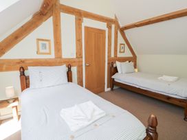 A bedroom with two beds and a door at Owl Cottage in Llangollen