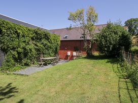 A garden with a table and chairs at Owl Cottage in Llangollen