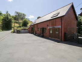 A brick building with planters and gate at Owl Cottage in Llangollen