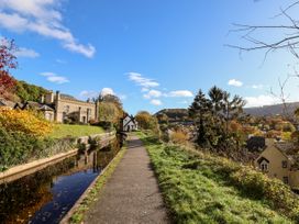 A path alongside a canal with buildings and trees at Owl Cottage in Llangollen