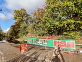 A canal with a boat and sign for horse-drawn boat trips at Owl Cottage in Llangollen