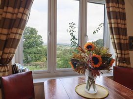 A dining room with a floral arrangement on the table at Upper Pandy Farm Welshpool