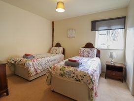A bedroom with two single beds and a bedside table at Upper Pandy Farm in Welshpool