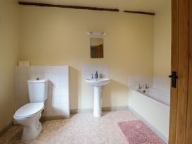 A bathroom with a toilet, sink, and bathtub at Upper Pandy Farm, Welshpool