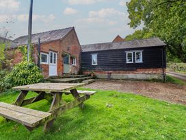 An outdoor view of a house with a picnic table at Upper Pandy Farm in Welshpool