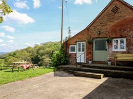 An outdoor area with a table and benches at Upper Pandy Farm in Berriew near Welshpool