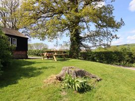A garden with a picnic table and tree at Upper Pandy Farm in Berriew near Welshpool