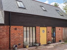 An exterior view of a house with a yellow door and flower pots at Jams in Lympstone