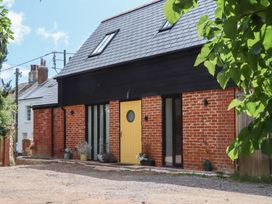 An exterior view of a house with a yellow door and brick walls at Jams in Lympstone