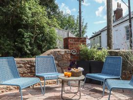 A garden with blue chairs and a table holding drinks at Jams in Lympstone