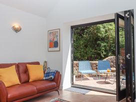 A garden room with a sofa and patio seating at Jams in Lympstone