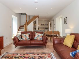 A living room with a sofa and dining area at Jams Lympstone