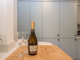 A kitchen with a bottle of prosecco and wine glasses at Jams in Lympstone