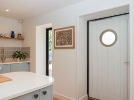 A kitchen with a sink and a round door at Jams in Lympstone