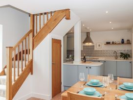 A kitchen with a staircase and dining table at Jams in Lympstone