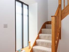 A staircase with a handrail and decorative items at Jams in Lympstone