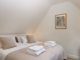 A bedroom with a bed and towels at Jams in Lympstone