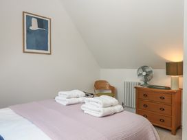 A bedroom with a bed, towels and furniture at Jams in Lympstone
