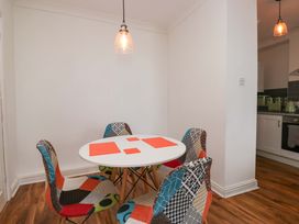 A dining room with a round table and colorful chairs at Duncan Square in Whitehaven