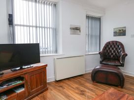 A living room with a television and an armchair at Duncan Square Whitehaven