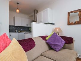 A living room with a sofa and kitchen area at Duncan Square in Whitehaven