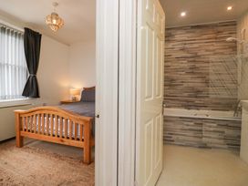 A bedroom with a bed and connecting bathroom at Duncan Square Whitehaven