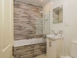 A bathroom with a bathtub, sink, and shower at Duncan Square in Whitehaven