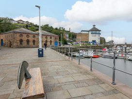 A marina with boats and buildings along the walkway at Duncan Square in Whitehaven