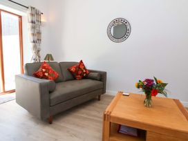 A living room with a sofa and a flower vase at Hedgehog Highway in Parkham