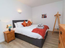 A bedroom with a bed and bedside lamp at Hedgehog Highway in Parkham
