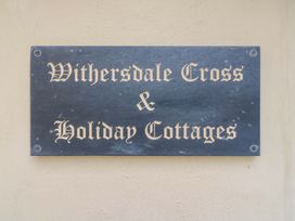 A sign for Withersdale Cross & Holiday Cottages