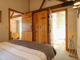 A bedroom with a bed and wooden doors at The Kiln near Mendham Harleston
