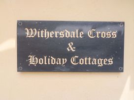 A sign for Withersdale Cross and Holiday Cottages