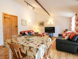 A living room with a dining table and television at The Golden Cross in Mendham near Harleston