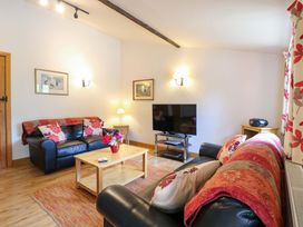 A living room with a sofa and a television at The Golden Cross in Mendham near Harleston