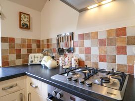 A kitchen with a gas stove and kettle at The Golden Cross in Mendham near Harleston