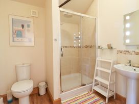 A bathroom with a shower, toilet, and wash basin at The Golden Cross in Mendham near Harleston