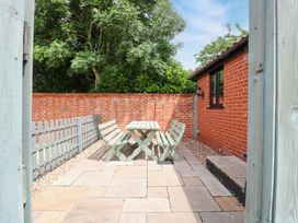 A garden with a table and benches at The Golden Cross in Mendham near Harleston