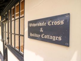 A sign for Withersdale Cross and Holiday Cottages