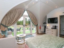 A bedroom with a sliding door and sofa at Crofters Suite