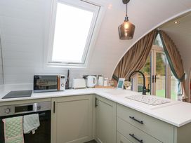 A kitchen with a microwave, kettle, and oven in Crofters Suite at 