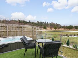 An outdoor space with a hot tub and seating area at Crofters Suite