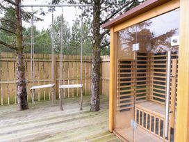 An outdoor area with swings and a sauna at Crofters Suite