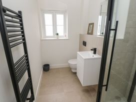 A bathroom with a toilet, wash basin, and shower at Ty Landsker in Milford Haven